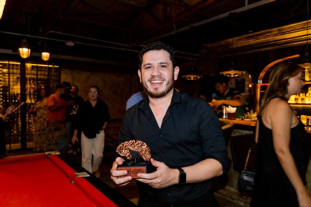 Romário Rocha segurando o troféu conquistado no Prêmio ACADi Juan Vazquez 2026, uma das principais premiações do mercado digital do Ceará.